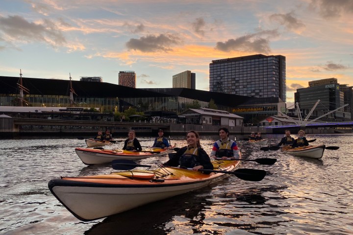 a small boat in a body of water with a city in the background